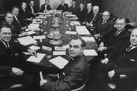 Black and white photo of men sitting around a table