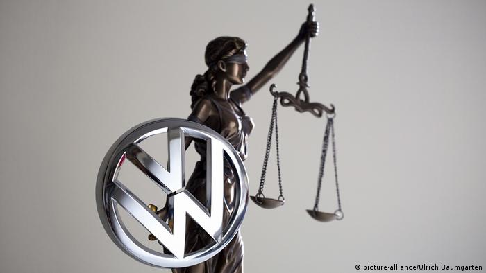Illustration of scales of justice with Volkswagon logo medallion